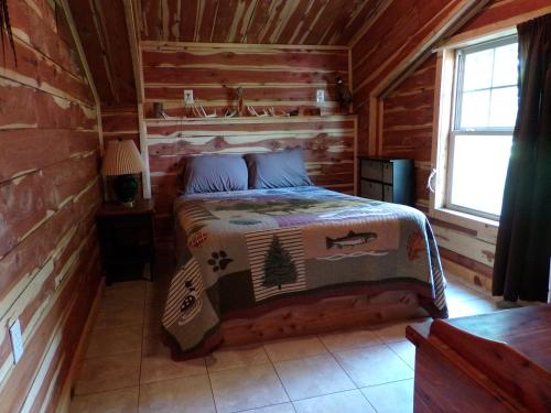 a bedroom with a bed in a log cabin at Cedar cabin located on a buffalo farm in Marshall