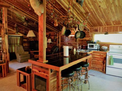 a kitchen with a island in a log cabin at Cedar cabin located on a buffalo farm in Marshall