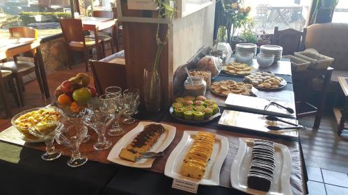 Una mesa con muchos platos de comida encima. en Suites de la Colina, en La Cumbrecita