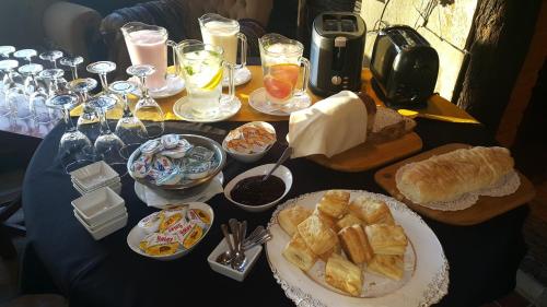 una mesa cubierta con placas de pan y otros alimentos en Suites de la Colina, en La Cumbrecita