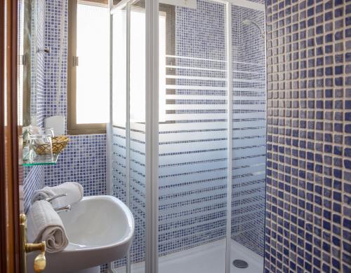 a bathroom with a sink and a glass shower at Pensión Las Palmas in Carboneras