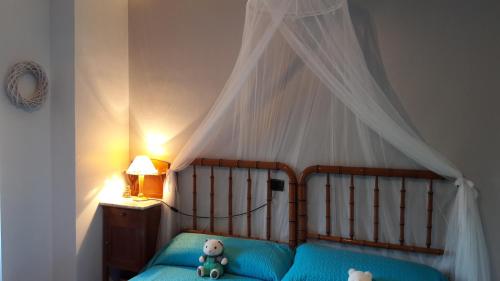 a bed with a canopy with a teddy bear on it at Casa Elina I I in Lucena del Cid