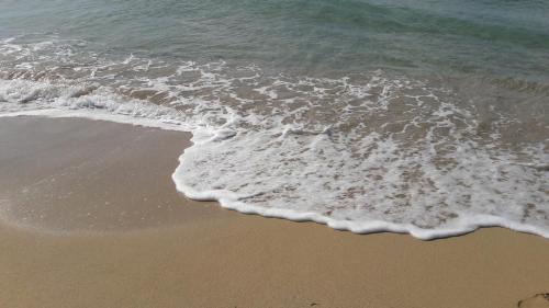an overhead view of the beach with the foamy water at La stanza del paradiso in Torre Pali 