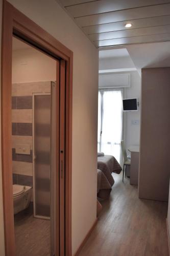 a room with a door leading to a bedroom at Hotel Arno in Misano Adriatico