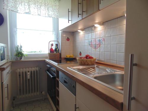 een kleine keuken met een wastafel en een raam bij Alpseeperle in Bühl am Alpsee