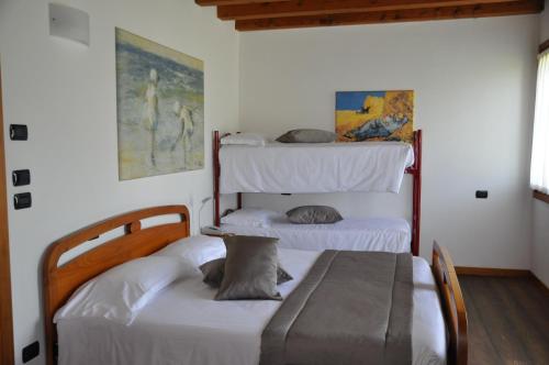 2 łóżka w pokoju z 2 łóżkami piętrowymi w obiekcie Agriturismo Ancillotto w mieście Meolo