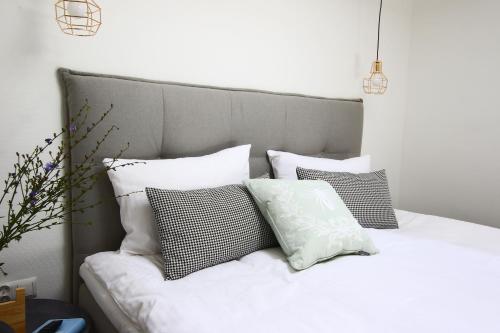 a bed with white pillows on top of it at Apartament Stary Port 1 in Bydgoszcz