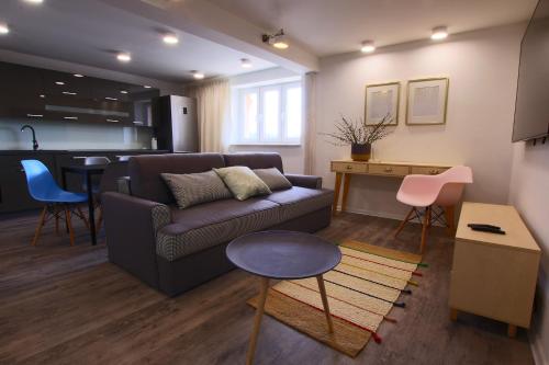 a living room with a couch and a kitchen at Apartament Stary Port 1 in Bydgoszcz