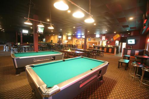 a pool table in a room with tables and chairs at Travelodge by Wyndham Brandon in Brandon