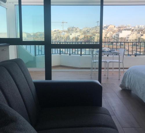 a living room with a couch and a bed and a table at Sunrise Creek in Marsaskala