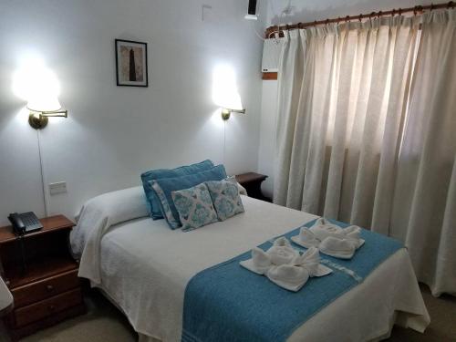 a bedroom with a bed with towels on it at Hotel Los Angeles in Gualeguaychú