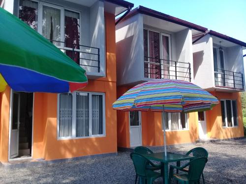 a table and an umbrella in front of a building at Twin Cottages in Ureki