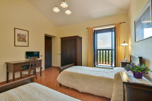 CastelcivitaにあるAgriturismo L'Antico Casolareのベッド2台と机と窓のある寝室