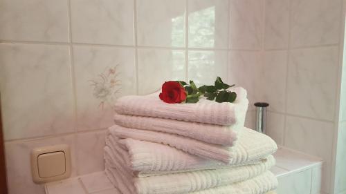 a stack of towels with a rose on top of them at Pension Waldfrieden in Wolkenstein