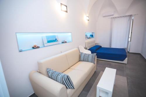 a living room with a white couch and a blue bed at IL VIAGGIATORE VIA INDIPENDENZA 2 in Gaeta