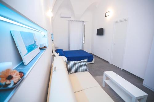 a living room with a white couch and a blue bed at IL VIAGGIATORE VIA INDIPENDENZA 2 in Gaeta
