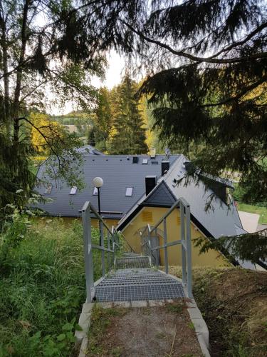 a staircase leading up to a house with a roof at Chatky Skalní mlýn Adršpach in Adršpach