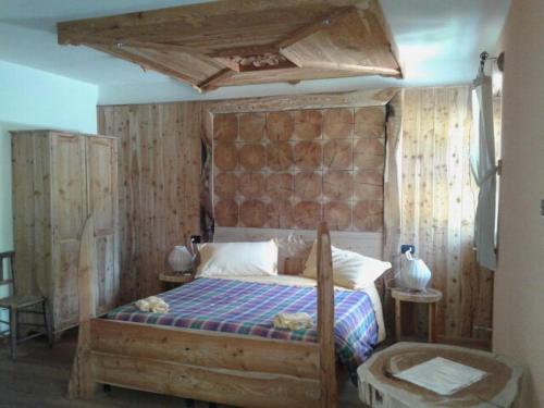 a bedroom with a bed with a wooden headboard at Albergo Passo Mortirolo in Monno