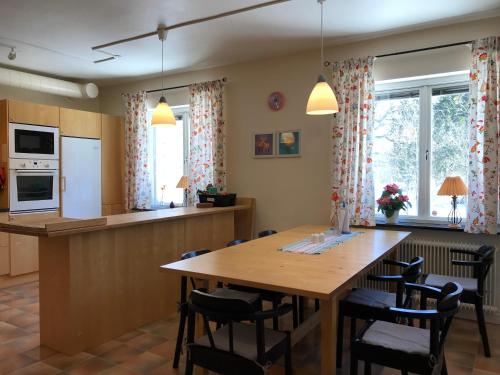 cocina y comedor con mesa de madera y sillas en Hågadalens Hostel & Vandrarhem, en Uppsala