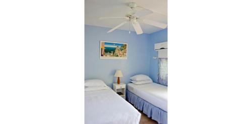 a bedroom with two beds and a ceiling fan at Meridian Inn in Christ Church