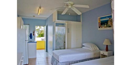 a bedroom with two beds and a ceiling fan at Meridian Inn in Christ Church