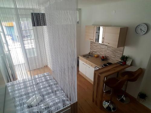 een kleine keuken met een aanrecht en 2 krukken bij Studio Apartment 'Dream' in Šibenik