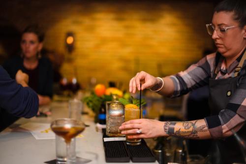 a woman making a drink at a bar at The Goodwin in Hartford