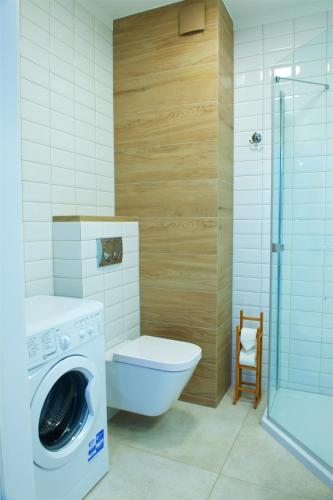 a bathroom with a toilet and a washing machine at Sea Cliff Apartment Rewal in Rewal