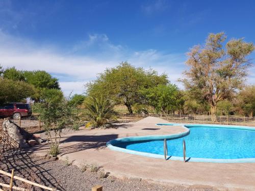 a swimming pool in the middle of a yard at Andes Nomads Desert Camp & Lodge in San Pedro de Atacama