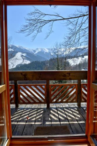 a view from the front door of a porch with snow covered mountains at Chata Zuzana in Terchová