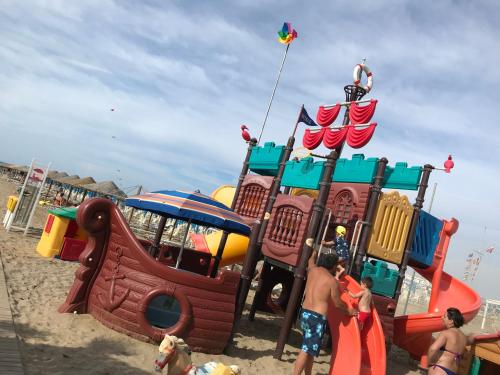a group of people playing on a playground on the beach at Appartamenti Villa Tonni in Gabicce Mare