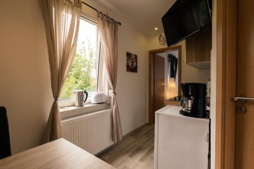 a small kitchen with a window and a refrigerator at Zimmervermietung Vock in Eschwege