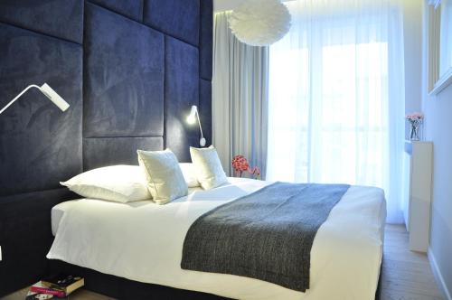 a bedroom with a large bed with a black headboard at City Rent Apartments in Łódź