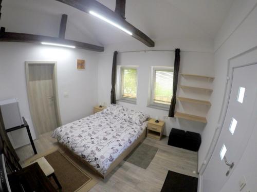 a small bedroom with a bed and a window at The Jungle Apartments and Rooms (Vila Džungla) in Bled