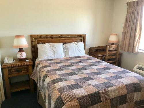 a bedroom with a bed and two night stands with lamps at Four Corners Inn in Blanding