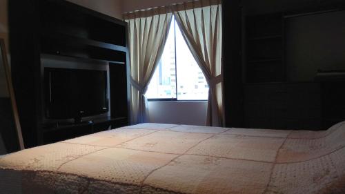 1 dormitorio con cama, ventana y TV en Kennedy Park 601 Apartment en Lima
