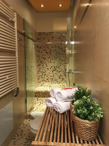 uma casa de banho com chuveiro e um banco com toalhas em Endless View Villa em Agios Nikolaos
