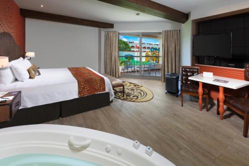 a hotel room with a large bed and a tub at Hard Rock Hotel Riviera Maya - All Inclusive in Puerto Aventuras