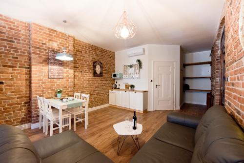 a living room with a couch and a brick wall at Apartament Starówka no1, no2, no3 in Toruń