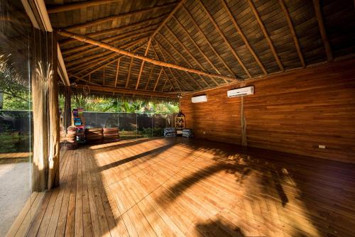 a large room with a wooden floor and a roof at Boutique Surf Hotel Rip Jack Inn in Playa Grande