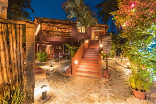 une maison avec un escalier menant à elle avec des lumières dans l'établissement Hotel Rip Jack Inn, à Playa Grande