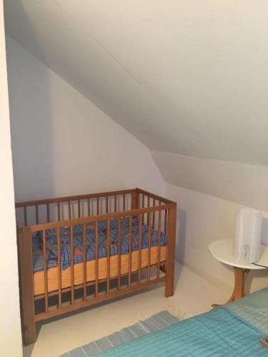 a crib in a bedroom with a white ceiling at Kolstigenhus in Fågelfors