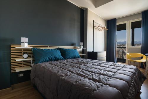 una camera da letto con un grande letto con cuscini blu di Turiddu B&B a Catania