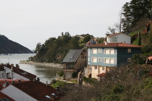 a group of houses on a hill next to a river at Hotel Brisas del Sella in Ribadesella