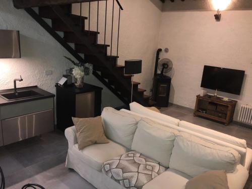 a living room with a white couch and a staircase at Laura's in Sesto Fiorentino