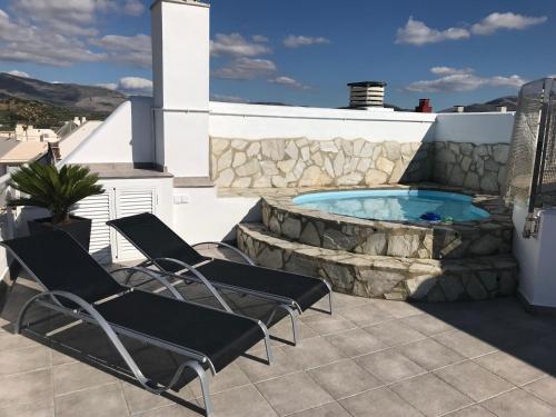 eine Terrasse mit Stühlen und einem Pool in der Unterkunft Puerta De Ronda in Ronda