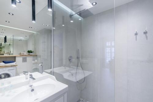 une salle de bain blanche avec lavabo et douche dans l'établissement Gdansk Old Town ul. Sw. Ducha 68 Apartments, à Gdańsk