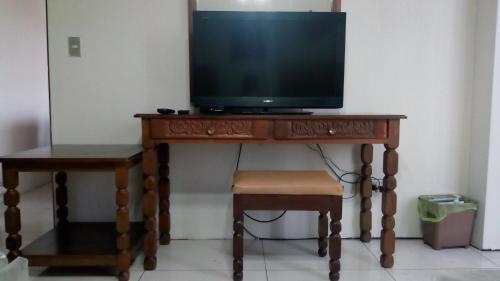 a television on top of a wooden table with a stool at Apartment business/airport area Guatemala City in Guatemala