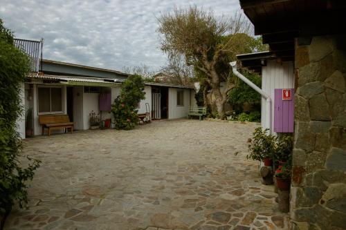 un patio vacío de una casa con un banco en Hostal El Conquistador, en Los Vilos