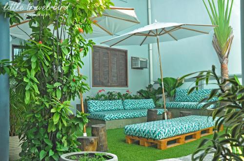 a patio with blue couches and an umbrella at Mango Tree Ipanema in Rio de Janeiro